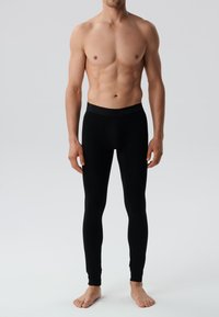 Czarne legginsy wykonane z gładkiego, elastycznego materiału. Posiadają bezszwowy pas z wytłoczonym napisem "PERFORM". Dopasowany krój.