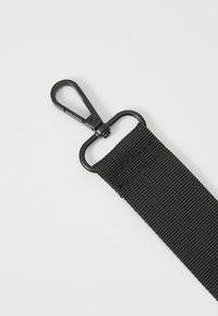 Sort nylonrem med en tekstureret overflade og metal snapkrog til sikker fastgørelse. Holdbar og alsidig til forskellige anvendelser.
