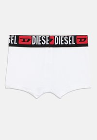 Άσπρα μπόξερ με μαύρη ελαστική μέση που φέρει το λογότυπο "DIESEL" σε λευκό και κόκκινο. Μαλακή υφή, απλός σχεδιασμός και μίνιμαλ διακοσμητικά στοιχεία.