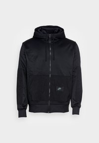Zwarte zip-up hoodie van gladde stof met een gestructureerd onderpaneel. Voorzien van een trekkoordcapuchon en een klein Nike-logo op het zakje.