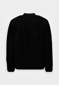 Svart fleecejacka med hög krage, texturerad yta och långa ärmar; har en sömlös design utan synlig hårdvara.