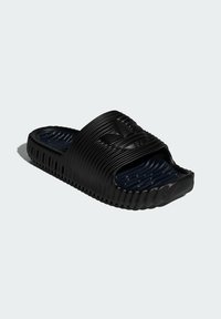 Sort slide sandal lavet af holdbart gummi. Har tekstureret overdel og sål med en rillede design. Åben tå stil med logo detaljer.