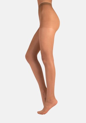 Donna che indossa collant sheer color nudo, in punta di piedi con le gambe unite su uno sfondo bianco semplice.