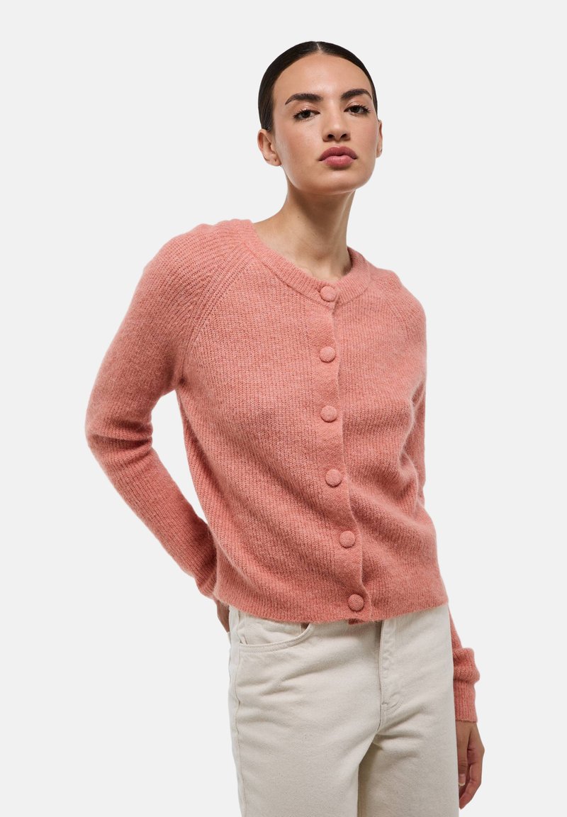 Cardigan en tricot rose avec un col rond, des manches longues et six boutons recouverts de tissu. Texture douce avec des accents côtelés.