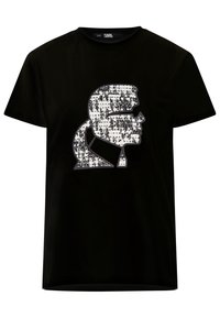 Black t-shirt featuring a white sequined design of a profile silhouette. Round neckline, short sleeves, and a relaxed fit.