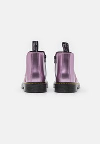 Lila metallicankelboots med slät yta, utrustade med dragkedja på sidan, svart gummisula och kontrasterande gula sömmar.