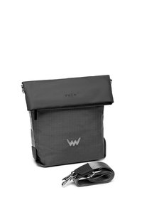 Černá a šedá messenger taška s přehnutým vrchem, texturovaný materiál, dekorativní logo a nastavitelné rameno s kovovým hardwarem.