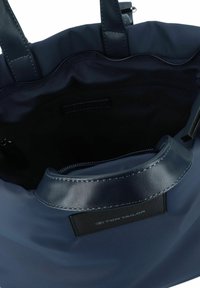 Bolso de mano azul marino con tejido suave y duradero y asas similares al cuero. Presenta un compartimento con cremallera en el interior para un almacenamiento seguro.