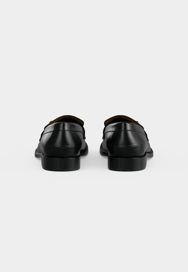 Pair of black leather formal shoes shown from the back on a plain light background with low heels and smooth finish.