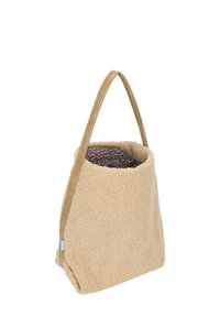 Borsa in pile beige con una superficie strutturata, corpo morbido e una maniglia robusta beige. L'interno è rifinito con un tessuto scuro con macchie chiare.