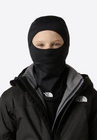 Črna balaklava iz raztegljivega materiala, združena s črno-sivo jakno z flis podlogo in logotipom The North Face.