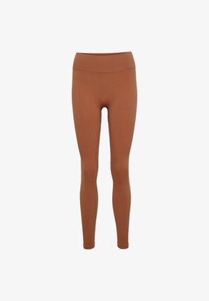 Bruna leggings tillverkade av ribbat tyg, med en hög midja och en åtsittande design som smalnar av vid anklarna.