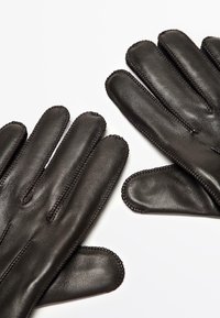 Schwarze Lederhandschuhe mit Fünf-Finger-Design, ausgestattet mit glatter Oberfläche und kontrastierender Naht entlang der Nähte. Keine Beschläge oder Akzente.