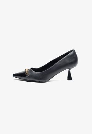 Scarpa con tacco alto nera in pelle, con punta a forma appuntita, caratterizzata da un accento di catena dorata sul collo del piede e un design unico del tacco a blocco.