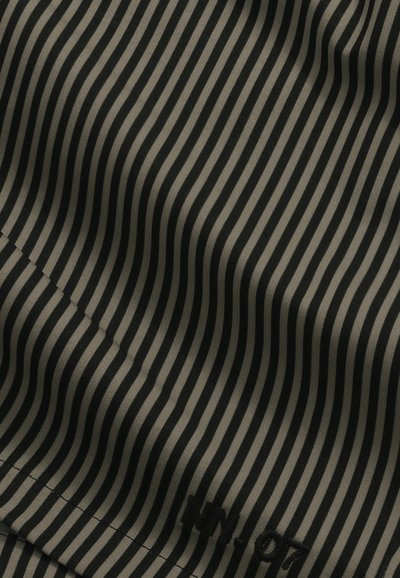 Gros plan d'un tissu rayé vertical noir et beige avec un texte noir brodé discret "NN-07" dans le coin.