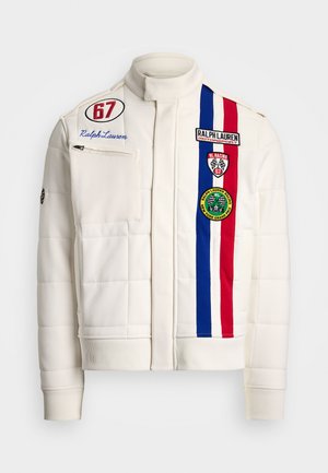 White quilted jacket with high collar, features blue, red, and white stripes, multiple patches, and a front zip pocket.