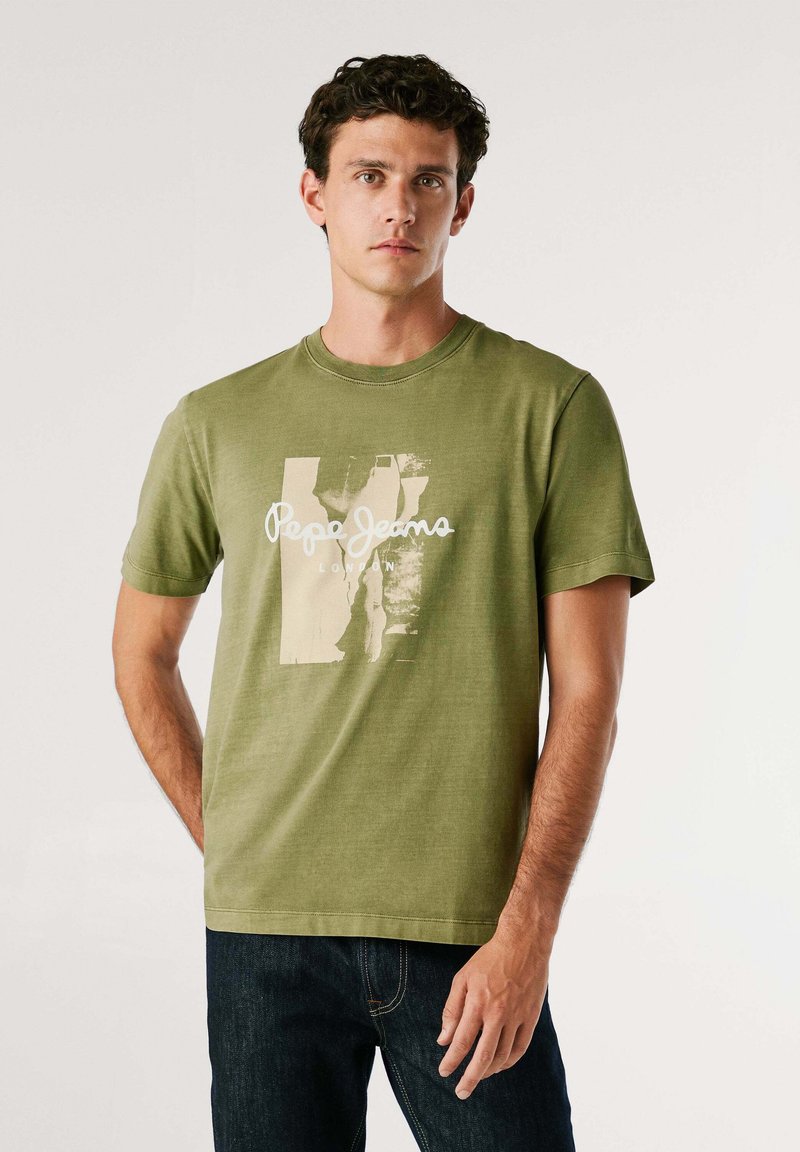 Olijfgroen katoenen T-shirt met korte mouwen, ronde hals en een grafisch ontwerp aan de voorkant met "Pepe Jeans London" in witte tekst.