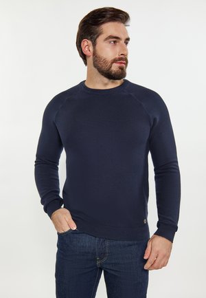 Maglione a maglia blu navy con collo rotondo e maniche raglan. Tessuto testurizzato e polsini a costine, con un piccolo logo sull'orlo.