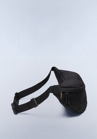 Marsupio in tessuto nero con tracolla regolabile e tasca con zip, posato su uno sfondo grigio chiaro.