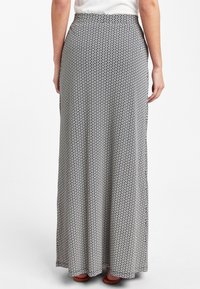 Falda larga con un estampado floral en blanco y negro. Tejido ligero y fluido, cinturilla elástica y una silueta recta.