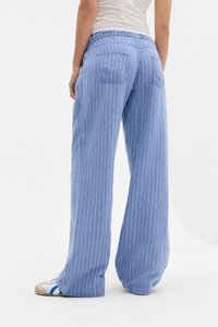 Calças largas de riscas azul claras, feitas de um tecido suave, apresentando um corte relaxado, costura detalhada e dois bolsos traseiros.