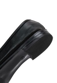 Zwarte lederen schoen met een ronde neus, een gestructureerde bovenkant en een platte rubberen zool. Heeft een gladde naad en subtiele branding op de zool.