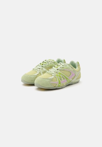 Paire de baskets sportives vert clair avec empiècements en mesh, accents violet pastel et lacets, posées côte à côte sur un fond blanc.
