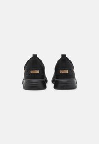 Zapatillas deportivas negras con un upper de textil suave, que cuentan con un collar acolchado, una cinta para tirar y un logotipo metálico en el talón.