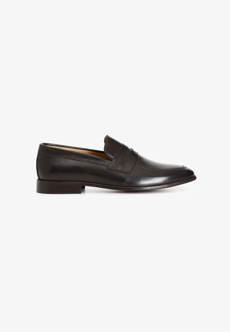 Mocasín negro de piel estilo 'penny loafer' con tacón bajo, puntera redondeada y detalle clásico de correa en la parte superior.