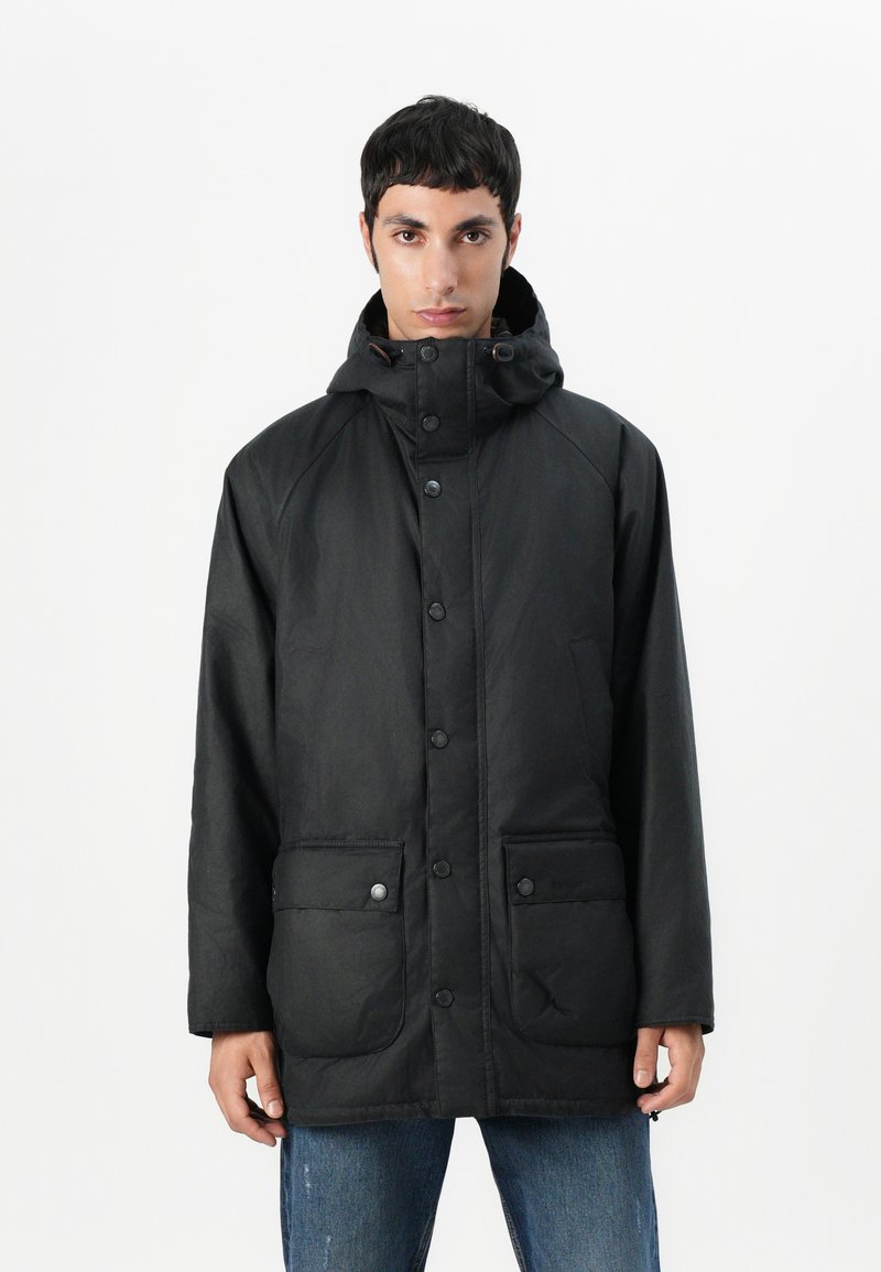 Μαύρο μπουφάν parka με ψηλό γιακά, μπροστιν�ούς κουμπιά και δύο μεγάλες μπροστινές τσέπες. Κατασκευασμένο από απαλό υλικό με ματ φινίρισμα.