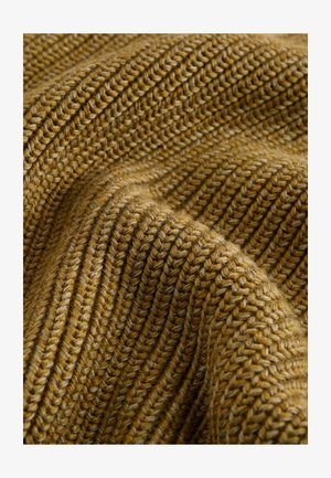 Tkanina iz preje v gorčično rumeni barvi, ki se ponaša z ribastim vzorcem z različnimi debelinami, kar ustvarja topel in mehak videz.