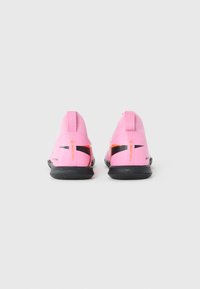 Pink athletic shoes with a sock-like design, black rubber sole, and black and orange accents on the sides. Smooth texture, minimal detailing.