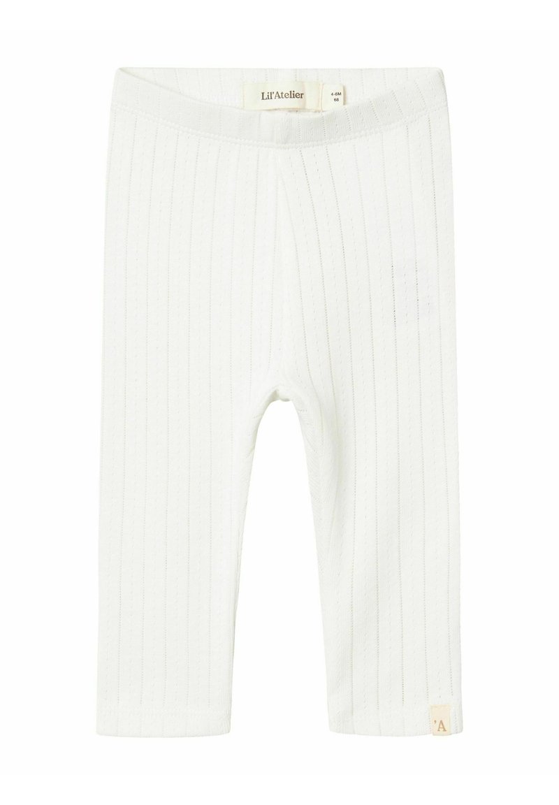 Leggings blancs côtelés en matériau doux, dotés d'une taille plate et d'une petite étiquette de marque au bord.