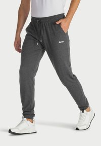 Gray jogger pants made of soft fabric, featuring an elastic waistband with drawstrings, side pockets, and a small white logo.