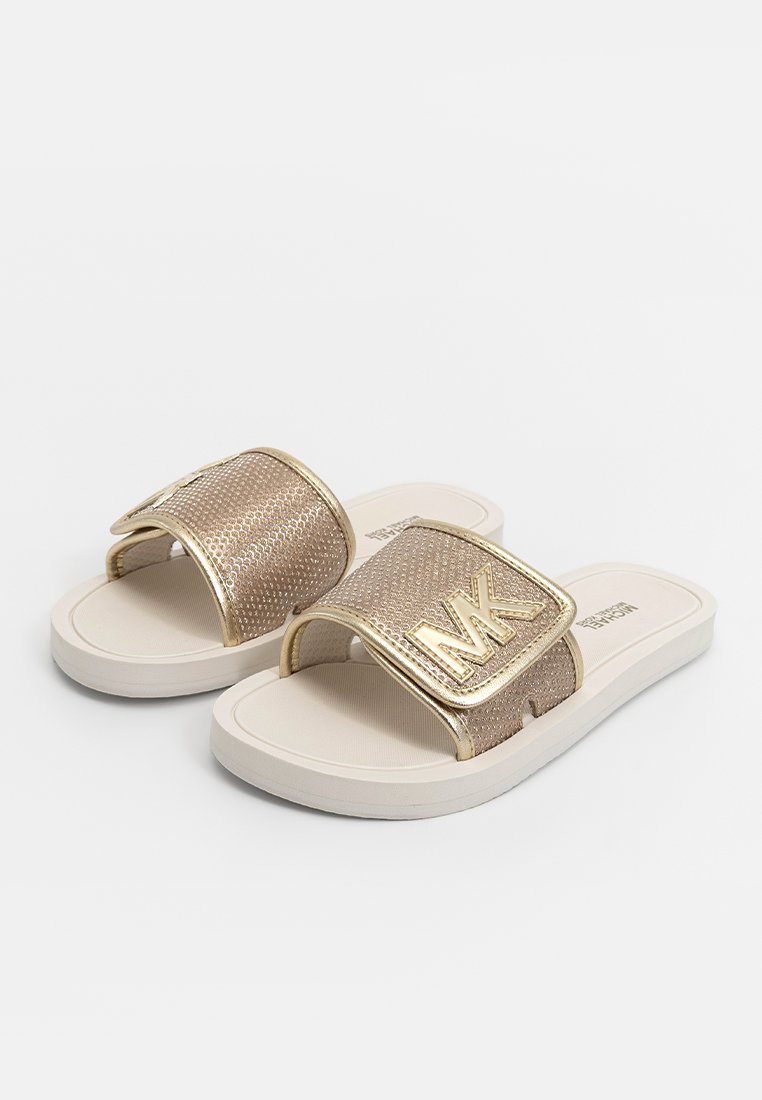 Sandales à glissière dorées et beiges avec une sangle texturée et un logo métallique, dotées d'une semelle en caoutchouc blanche et d'un pied confortable.