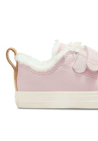 Zapatilla de cuero rosa con suave forro de lana blanca, correa de Velcro y lengüeta de talón texturizada en color marrón claro. Suela de goma blanca.