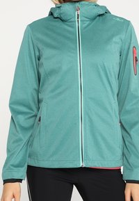 Teal waterdichte jas met capuchon, voorzien van een rits aan de voorkant, zijzakken en een contrasterende rits in lichtblauw. Zachte textuur.