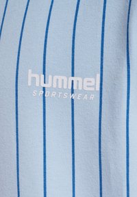 Helles blaues Sportoutfit mit vertikalen blauen Streifen, versehen mit dem "hummel"-Logo und dem Wort "SPORTSWEAR" in weißem Text, hergestellt aus weichstem Stoff.
