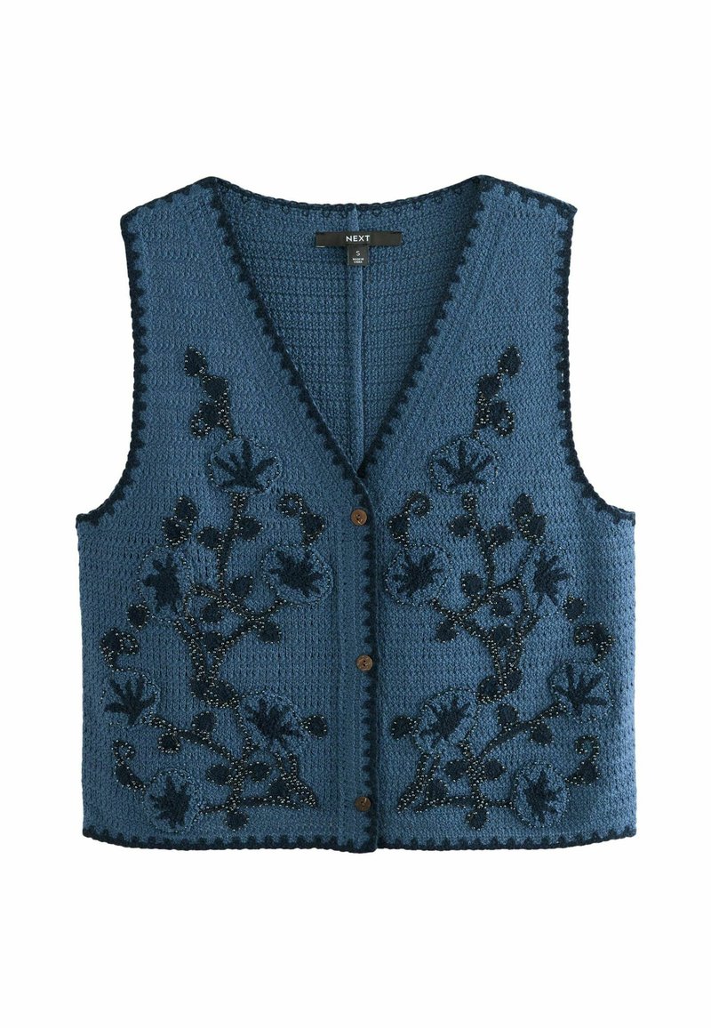 Stickad blå väst med V-ringning, prydd med svart blommönsterbroderi och små bruna knappar. Texturerad tyg med vågiga kanter.