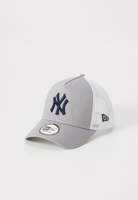 Grå caps med hvite mesh-paneler, med en marineblå brodert logo foran og et merket skjold på undersiden av visiret.