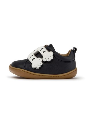 Scarpa nera per bambino con suola marrone e due strisce in velcro bianche a forma di clown per la chiusura su sfondo bianco.