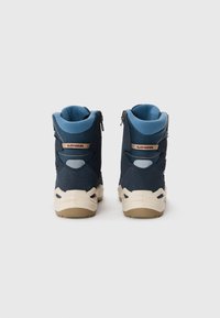 Blaue und marineblaue Wanderschuhe mit strukturiertem Obermaterial, gepolstertem Schaft und beiger Sohle. Mit einem Reißverschluss und Markenlogo an der Ferse.