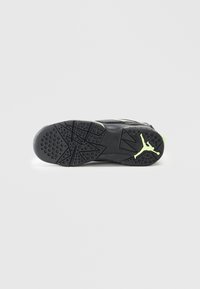 Suola nera di scarpa sportiva con motivi di presa in gomma testurizzati e un accento verde vicino al tallone, caratterizzata da un logo Jumpman in lime.