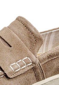 Scarpa slip-on in suede marrone con superficie testurizzata, dotata di una fodera a righe e accenti decorativi in argento.