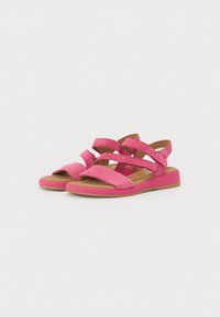 Rosa semskede sandaler med kryssremmer og åpen tå. Har en flat såle med rosa detalj rundt kanten. Myk tekstur og uformell design.