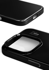 Svart telefondeksel med blank finish, med presise utskjæringer for knapper og kamera. Litt forhøyede kanter, inngravert logodetalj.