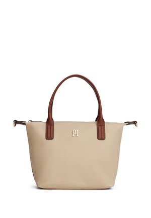Beige handlenett med brune håndtak, lite gyllent logo midtstilt under håndtakene, og glidelåslukking på toppen.