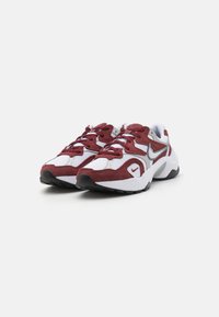 Scarpe sportive rosse e bianche con una tomaia in mesh e suede. Presentano una suola testurizzata, un collarino imbottito e un logo Nike swoosh argentato.