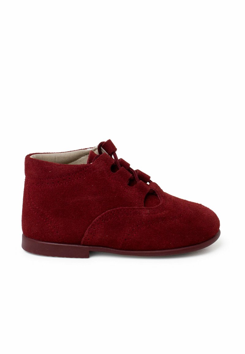 Botas de tobillo de ante rojo con punta redondeada, diseño con cordones y detalles troquelados. Cuenta con una suela plana y una superficie texturizada.