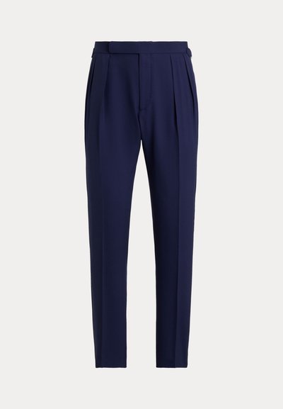 Pantalon bleu marine coupé sur mesure avec plis sur le devant, poches latérales, passants pour ceinture, et coupe slim effilée.